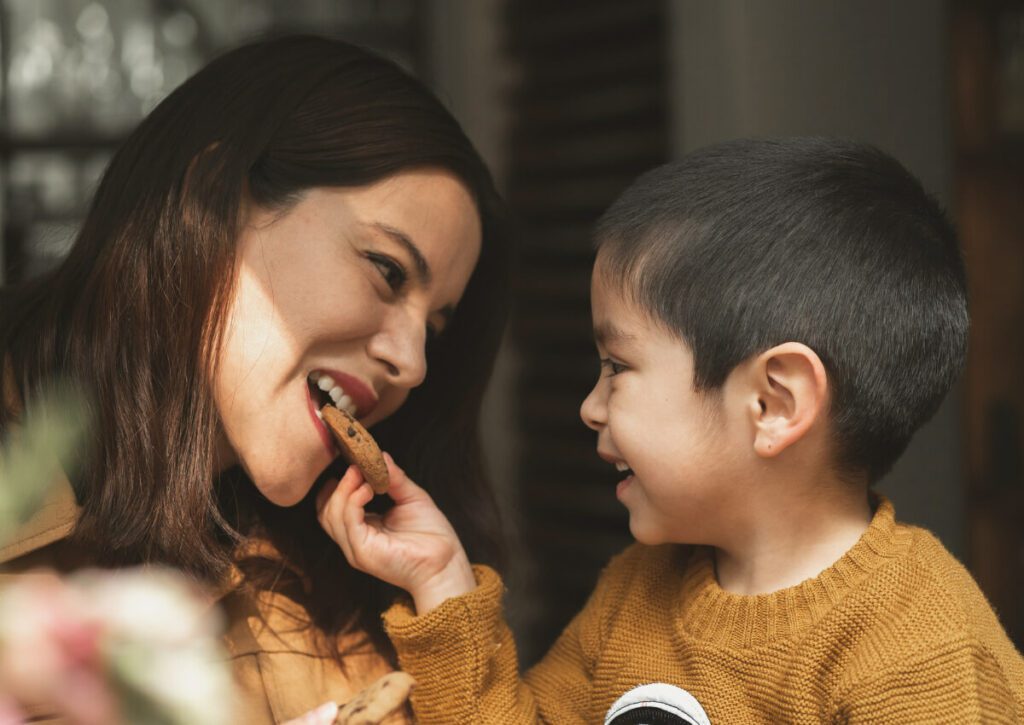 Mom with son, and son is feeding Mom a cookie.