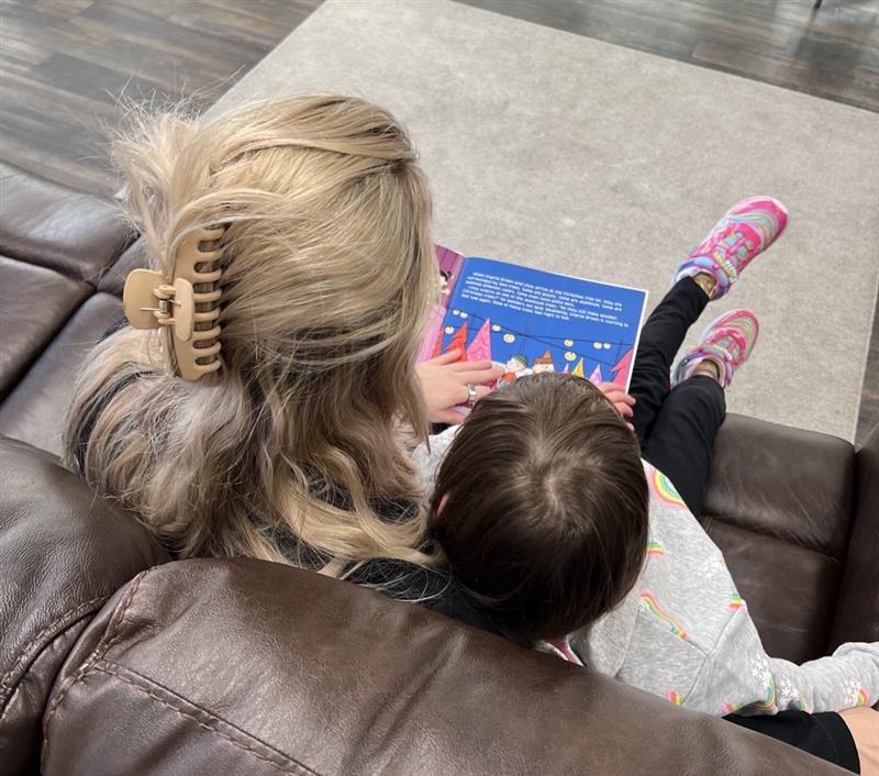 Registered Behavior Technician reading book to child/client.