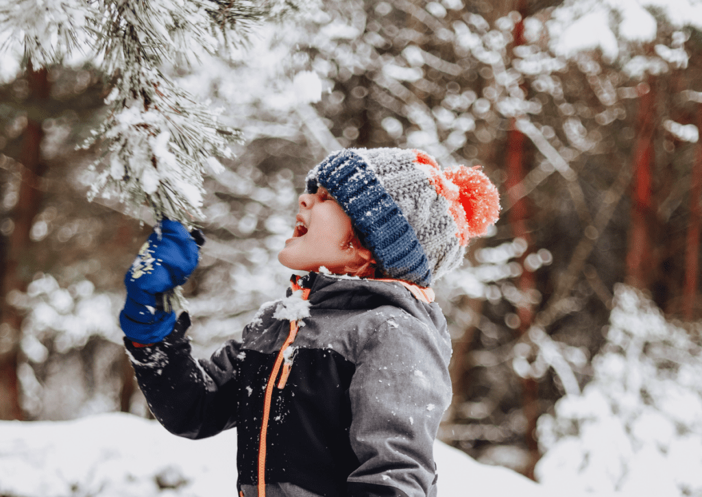 boy plays outside in snow.