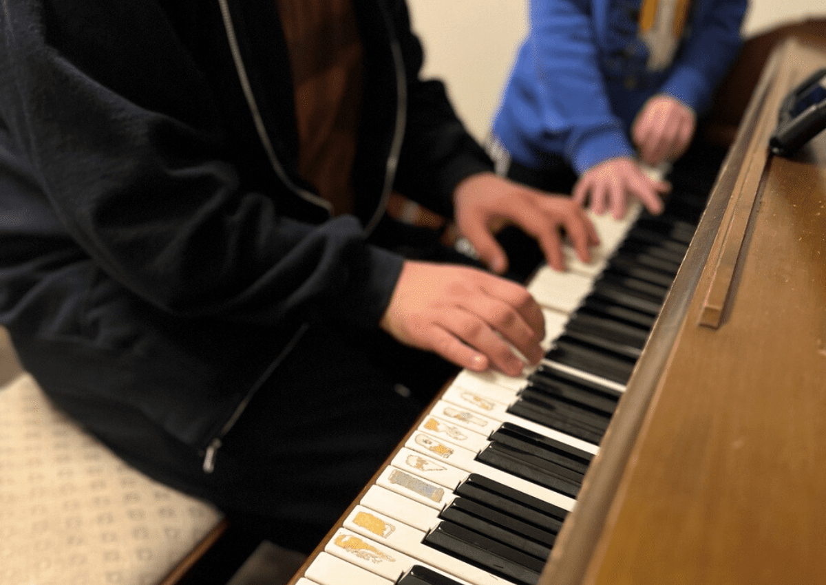 Two people playing the piano together.